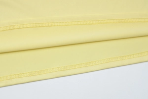 Close-up of yellow fabric with precise double-needle stitching and smooth texture