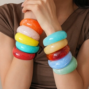 Colorful wide resin bangles featuring marble patterns and vibrant summer aesthetic