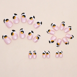 Faux ongles ovales à motif vache avec base rose aurore et motifs abstraits noirs et jaunes