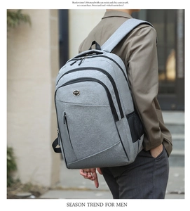Detail view of grey oxford fabric business backpack with multiple zipper pockets