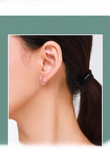 Close-up of minimalist S925 sterling silver heart hoop earrings worn on a female ear