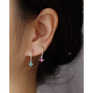 Macro view of S925 silver clover earrings with inlaid blue and pink gemstones on model