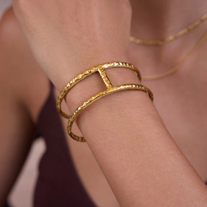 Detail of 18K gold stainless steel double-layered cuff bracelet with hammered texture