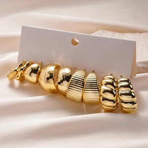 Detail of 5 pairs of textured gold C-shaped earrings with hammered and wavy finishes