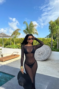 Détail d'une robe longue transparente en mesh noir portée en cache-maillot au bord d'une piscine
