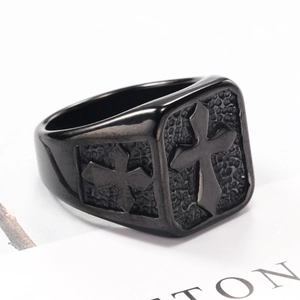 Macro detail of retro stainless steel ring featuring a black cross and stone texture