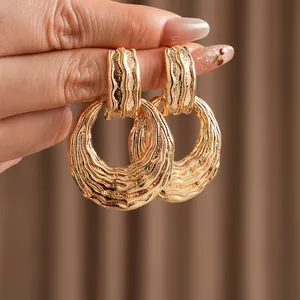 Textured gold hoop earrings with irregular ripple surface and luxury metal finish