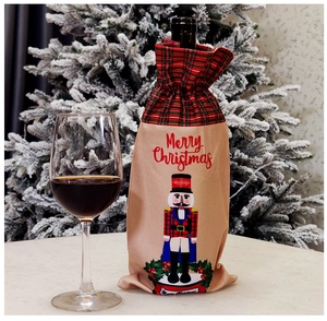 Close-up of beige linen wine bottle cover with nutcracker soldier and Merry Christmas print
