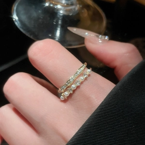 Detail of double-layer gold ring with shimmering cubic zirconia and round pearls