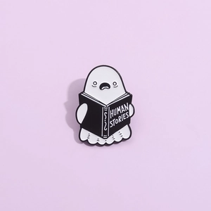 Ghost enamel pin holding a Human Stories book, creative Halloween badge accessory