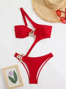 Detail of red one-shoulder swimsuit featuring waist cut-outs and gold heart metal rings