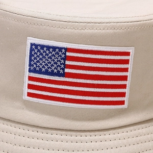 Close-up of the American flag embroidery and thick cotton canvas texture on beige bucket hat