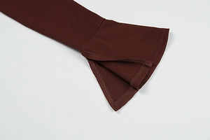 Detailed close-up of dark burgundy bell sleeves with side slits and clean stitching