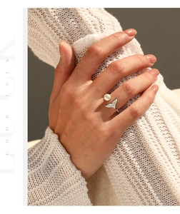 Detail showing an elegant S925 silver fishtail ring with pearl on model hand