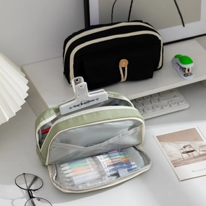 Detail of large capacity canvas pencil case showing interior compartments and mesh pocket