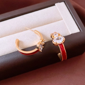 Detail of red enamel C-shape hoop earrings with zircon in a premium leather jewelry box