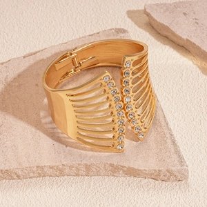 Detail eines goldenen Manschettenarmbands mit doppelreihigen Diamanten auf Stein