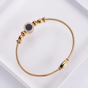 18k gold plated stainless steel wire bracelet with black circular inlay and zircon accents