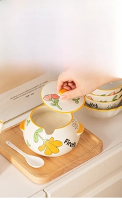 Macro shot of floral ceramic lard jar with lid and matching spoon on wooden tray