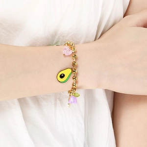 Detail of gold beaded bracelet featuring avocado, pink heart, and floral enamel charms