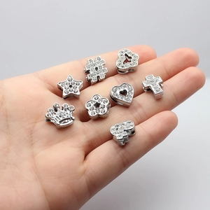 Close-up of silver rhinestone charms in star, crown, and heart shapes for DIY bracelets
