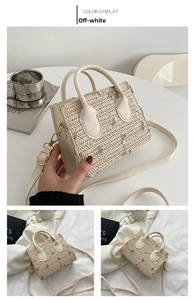 Detail of off-white straw woven bag with green floral embroidery and leather handle