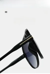 Detail of the iconic metal T-hinge on oversized black pilot sunglasses with sleek temples