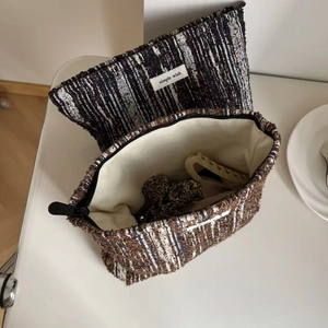 Macro detail of tweed textured makeup bag with zipper closure and woven interior lining