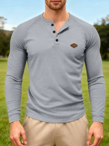 Detail shot of men's grey waffle knit Henley shirt with buttons and leather patch