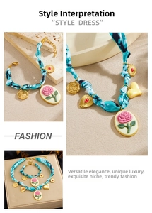 Detailed close-up of blue tie-dye fabric necklace with gold heart and rose oval pendants