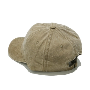 Detail of khaki baseball cap featuring vintage washed texture and adjustable metal buckle