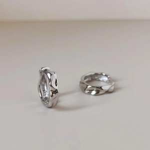 Detailed macro view of S925 sterling silver earrings with irregular wavy texture