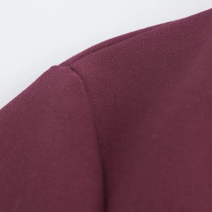 Détail macro de la couture d'épaule et texture du tissu tissé sur cette robe polo bordeaux