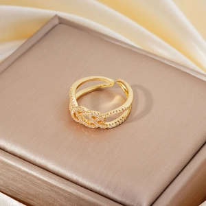 Close-up of golden double-layered knot ring with micro-set cubic zirconia on display box