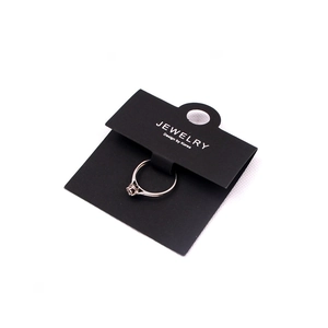 Silver jewelry ring with zircon inlay displayed on black jewelry packaging card