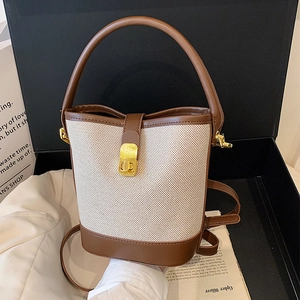 Vintage canvas bucket bag with brown leather trim and golden clasp in a gift box