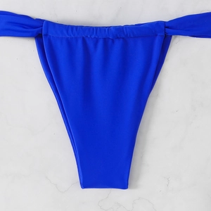 Detailed close-up of vibrant royal blue bikini bottoms on white marble background