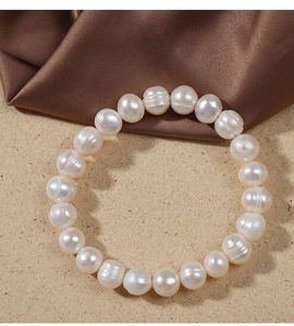 Detailed view of white freshwater pearls with natural textures on a silk and stone surface