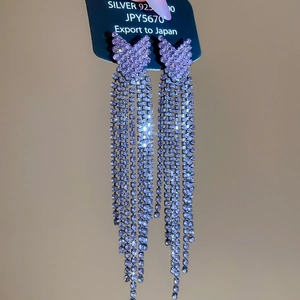Detail of silver S925 purple crystal earrings featuring long sparkling tassels