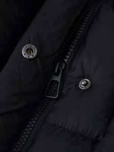 Detail of high-quality black nylon fabric with zipper and metallic snap buttons