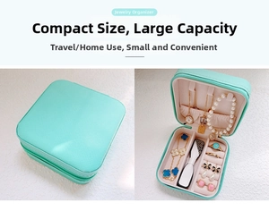 Detail of mint green portable jewelry box with zipper and multi-compartment interior
