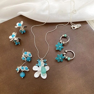 Detail view of floral necklace and earrings set with turquoise and blue beads