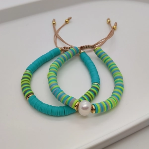 Close-up of bohemian woven beaded bracelets with natural pearls and Heishi beads