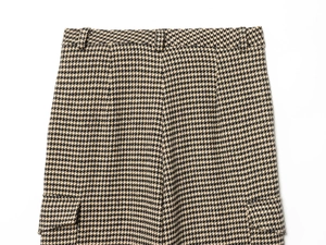 Detailed view of houndstooth cargo pants featuring a side flap pocket and belt loops