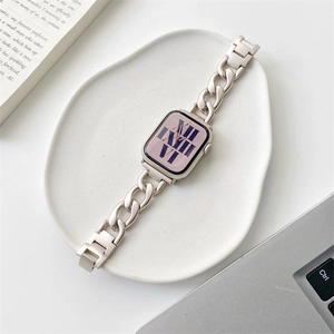 Champagne gold metal chain strap for Apple Watch on a minimalist white ceramic tray