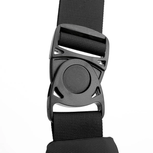 Macro shot of a heavy-duty quick-release plastic buckle on the black nylon backpack strap