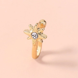Close-up of golden star-shaped non-piercing nose ring with a central sparkling zircon