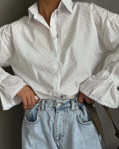 Detail of white cotton shirt with polka dot texture and delicate lace cuffs for women