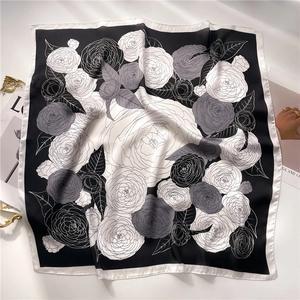 Detail view of a camellia floral silk scarf with elegant black and white monochrome patterns