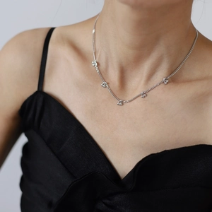 Minimalist cherry fruit pendant necklace in polished steel worn on collarbone